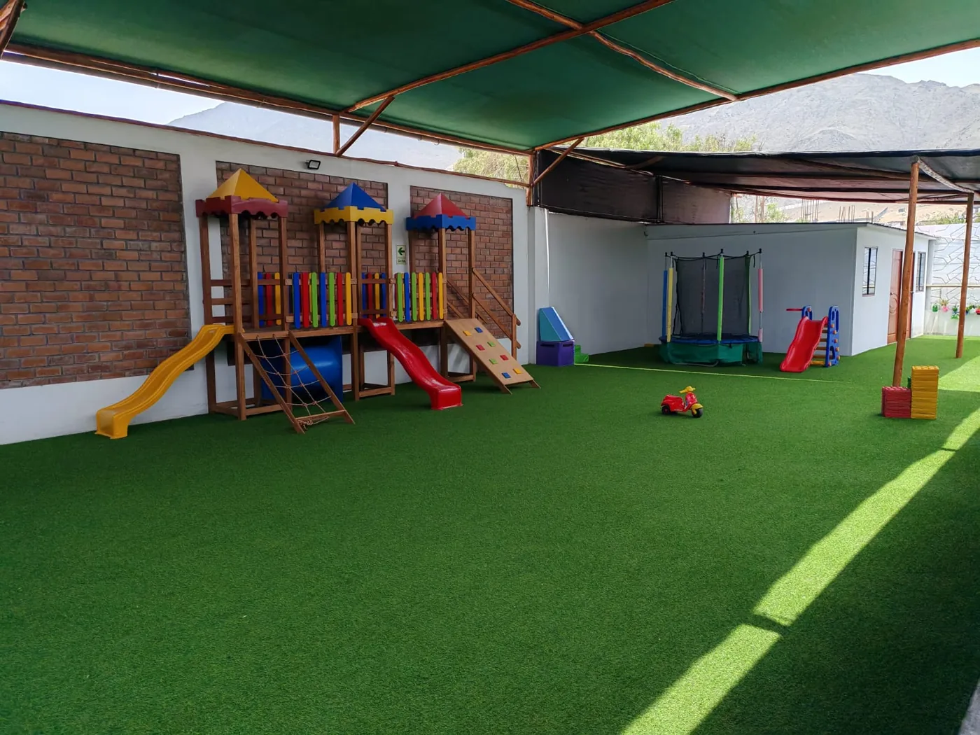 Patio con grass sintético y zona de juegos del colegio